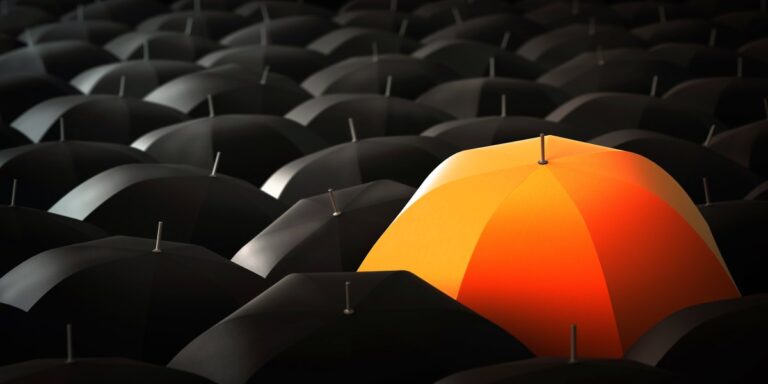 insuretech100 orange Tapoly umbrella in a sea of black umbrellas